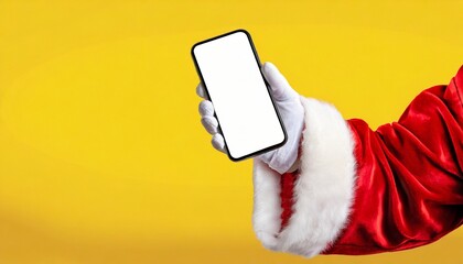Hey, new cellphone. Santa holding modern phone with white blank screen over orange background, panorama. Image of hand of santa claus holding smartphone with blank screen and copy space on background.