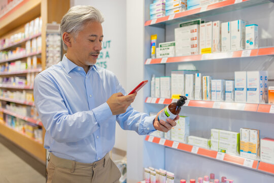 Man using cellphone and checking bottle label in store