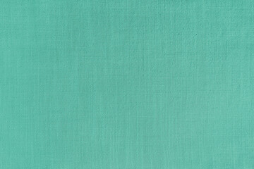 Texture background of turquoise linen fabric. Textile structure, cloth surface, weaving of natural cotton fabric closeup, backdrop, wallpaper.