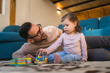 Adult caucasian man father play with daughter two years old girl