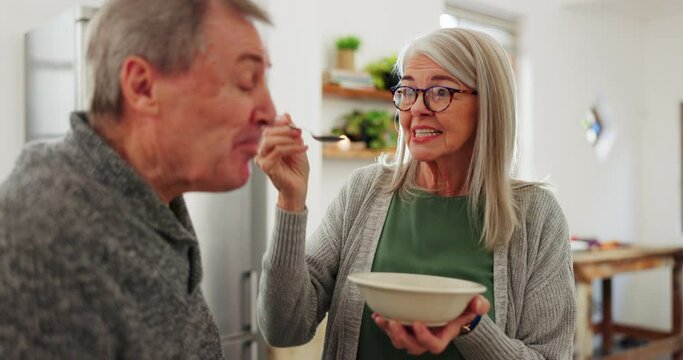 Eating, senior couple and feeding breakfast, taste test and care with help in marriage. Happy, talking and an elderly man and woman with food, lunch and dinner for nutrition together in a house