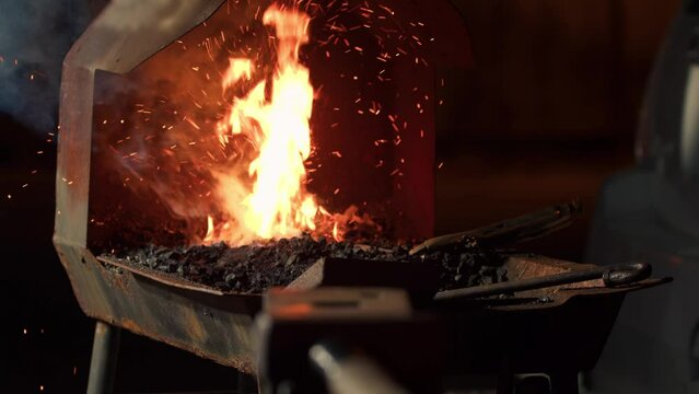 Blacksmith heats a metal product in a furnace for further processing