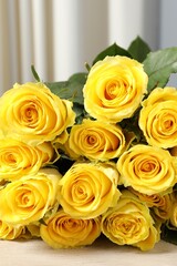 Beautiful bouquet of yellow roses on wooden table, closeup