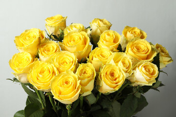 Beautiful bouquet of yellow roses on light grey background, closeup