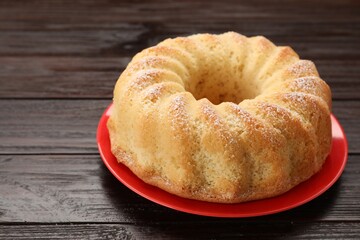 Delicious freshly baked sponge cake on wooden table, closeup. Space for text