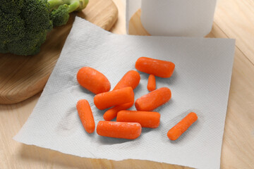 Carrots drying on paper towel on wooden table, closeup