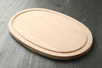 One wooden cutting board on dark grey table