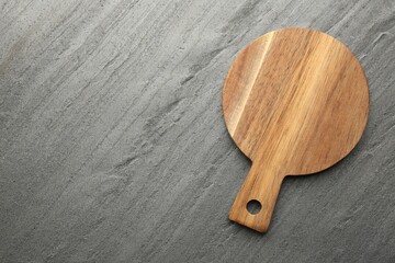 One wooden cutting board on dark grey table, top view. Space for text