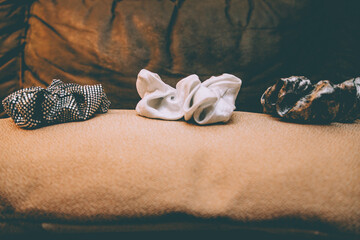 Three scrunchies on top of a beige cushion on the sofa
