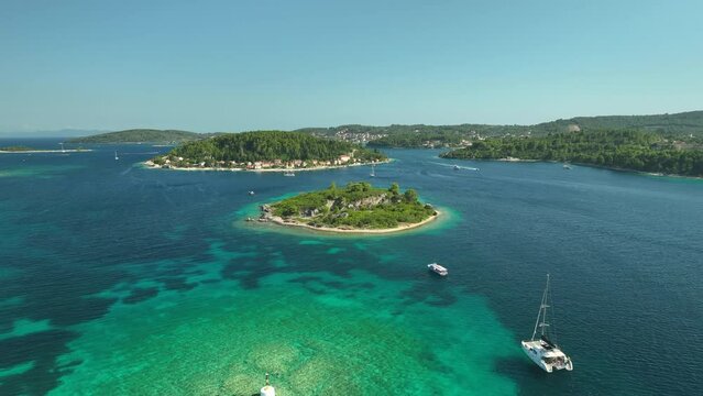 Luxury yachs anchored in shallow water at Korcula islands in Croatia on a sunny day. Drone dolley shot