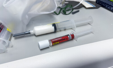 Clinical setting with medications, syringes, and needles on a hospital tray, symbolizing healthcare and treatment