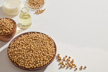 Soybean oil, milk and seed contained inside laboratory glassware and wooden containers over white background. Vacant space for product advertising