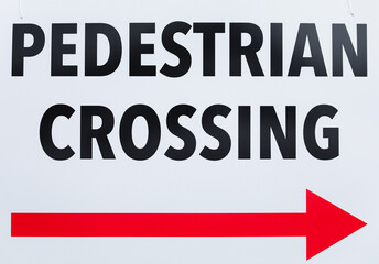 Pedestrian sign on bustling city street guiding pedestrians safely across, urban safety concept
