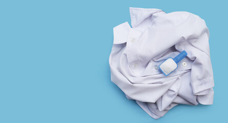 Detergent powder in measuring spoon on cloth before washing. Laundry concept.