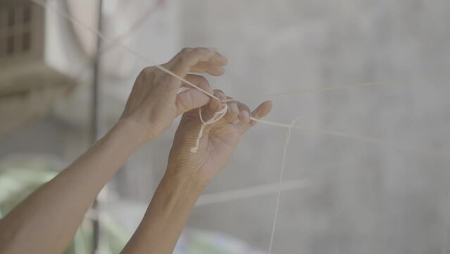 (V-Log) Hands making a Knot of a white thick thread