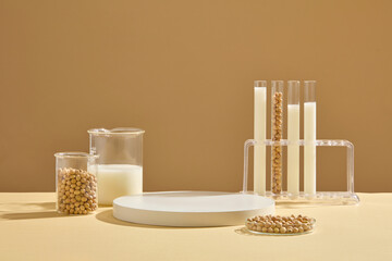 A petri dish, beaker and test tubes on the rack containing soybeans and milk displayed with a podium. Blank space on the podium to display product extracted from Soybean (Glycine max) - obrazy, fototapety, plakaty