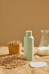 Cosmetic bottle displayed with a bowl of soybeans. A conical flask and petri dish of soybean milk...