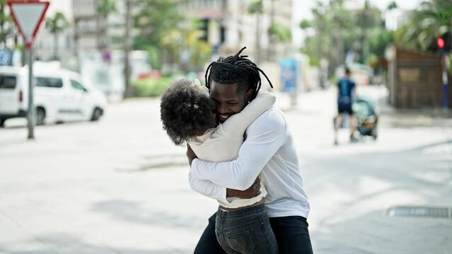 African american father and daughter smiling confident hugging each other at street