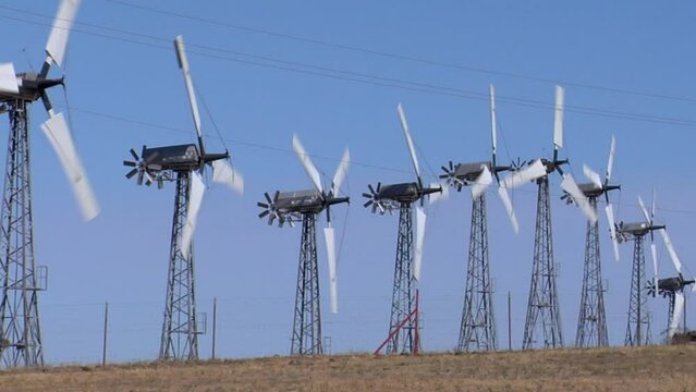 Wind turbines working in Altamont Pass wind farm under blue sky on a sunny day in California, USA