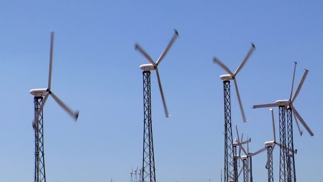 Wind turbines in Altamont Pass wind farm under blue sky on a sunny day in northern California, USA