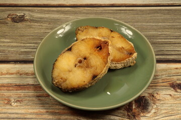 Pile of deep fried barracuda fish fillet serving on the plate. Famous appetizer and starter seafood menu in Asia restaurant.