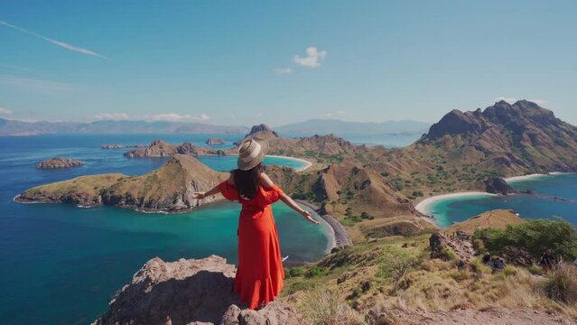 Young female tourist enjoying the beautiful landscape at Padar island in Komodo National Park, Indonesia