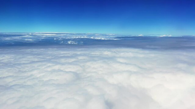 View of white clouds and clear sky ,looking through airplane windows while traveling.