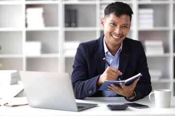 Businessman working with laptop on desk in office.