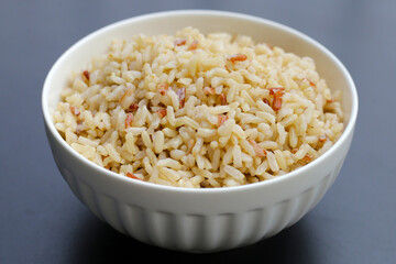 Cooked brown rice on dark background.