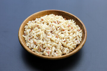Cooked brown rice on dark background.