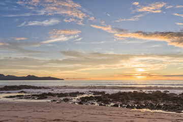 Dusk on the Ocean with a Rocky Beach in the Foreground