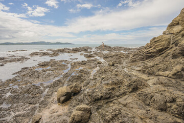 Man in the distance on a rocky beach in Playa Flamingo, Costa Rica.