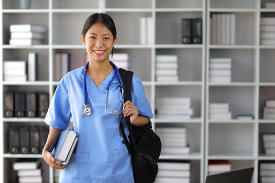 Internship medical students carry bags and textbooks in the library.