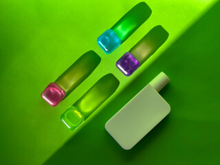 Cosmetic bottle and coloured transparent cubes. Sunlight and shadows