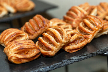 Appetizing crispy pastries with jam on a black stone tray. Organizing events and business meetings. Close-up.
