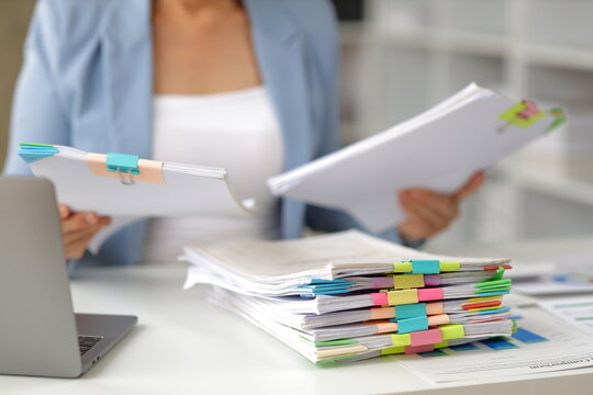 Senior businesswoman is stressed from doing too much paperwork.