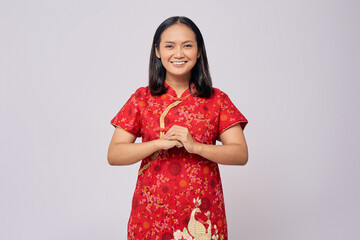 Happy Chinese New Year. Young Asian woman wearing traditional cheongsam qipao dress with gesture of...