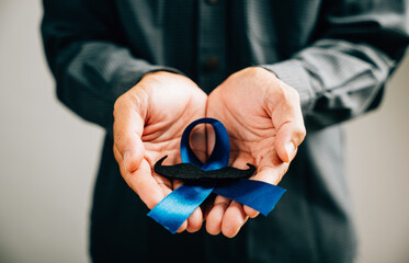 November, Prostate Cancer Awareness Month, A Blue Ribbon with a mustache symbolizes support for...