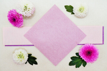 クリーム色のサテンの布を背景に白とピンクの丸い菊の花と可愛いメッセージスペースのモックアップ