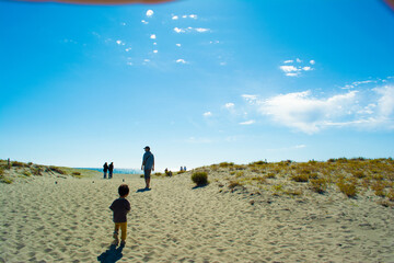 中田島砂丘を歩く親子の後ろ姿と青空