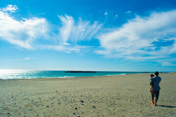 中田島砂丘を歩く親子の後ろ姿と海と青空
