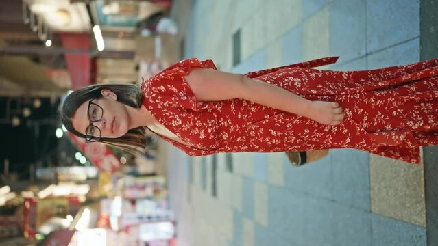 Energetic night in osaka, brunette hispanic woman, radiant with confidence, flaunts a joyful smile on shinsekai street, cheery city lights reflecting in her glasses