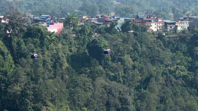 A cable car crossing a deep gorge covered with trees in Kushma, Nepal.