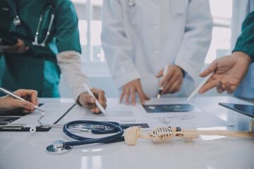 Multiracial medical team having a meeting with doctors in white lab coats and surgical scrubs...