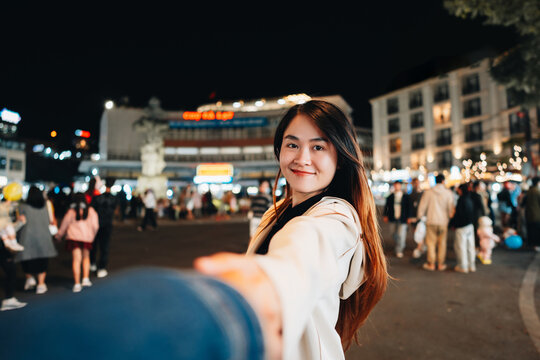 Lover women hand holding a men asians travel and enjoy at Da Lat night market, Vietnam