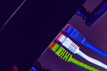 Cables plugged in a Wi-Fi router on dark background