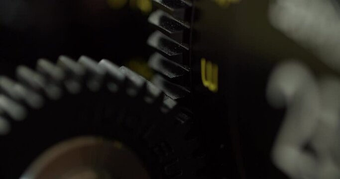 Macro shot oof the focus gear on a cinema lens. Gear moving and changing the focus of the lens.