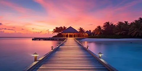 Poster Sunset on Maldives island, luxury water villas resort and wooden pier. Beautiful sky and clouds and beach background for summer vacation holiday and travel concept © Rozeena