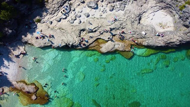 People enjoy rocky coast of Bruce peninsula and crystal clear lake water, aerial top down view