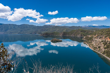 The reflection of blue sky and white clouds on the water surface of Lugu Lake in China